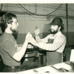 An photo of an early Lighthouse employee who is DeafBlind communicating with an interpreter