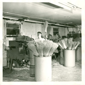 Vintage photo of a Lighthouse employee making brooms in the early years of the organization